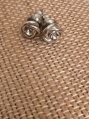 Silver tone love knot post earrings with clear rhinestone center